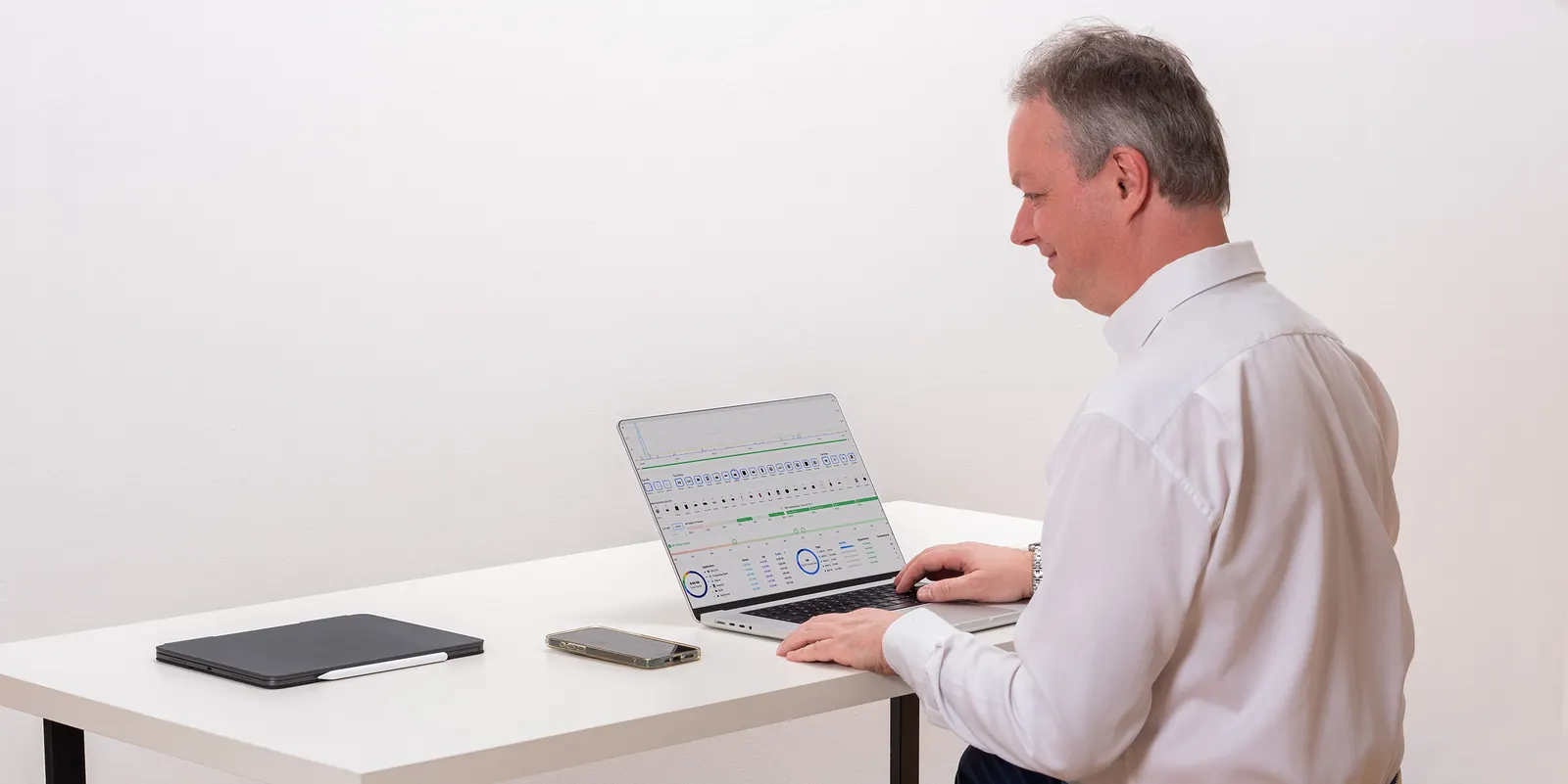 Aufgeräumter Schreibtisch mit Laptop, Tablet und Smartphone